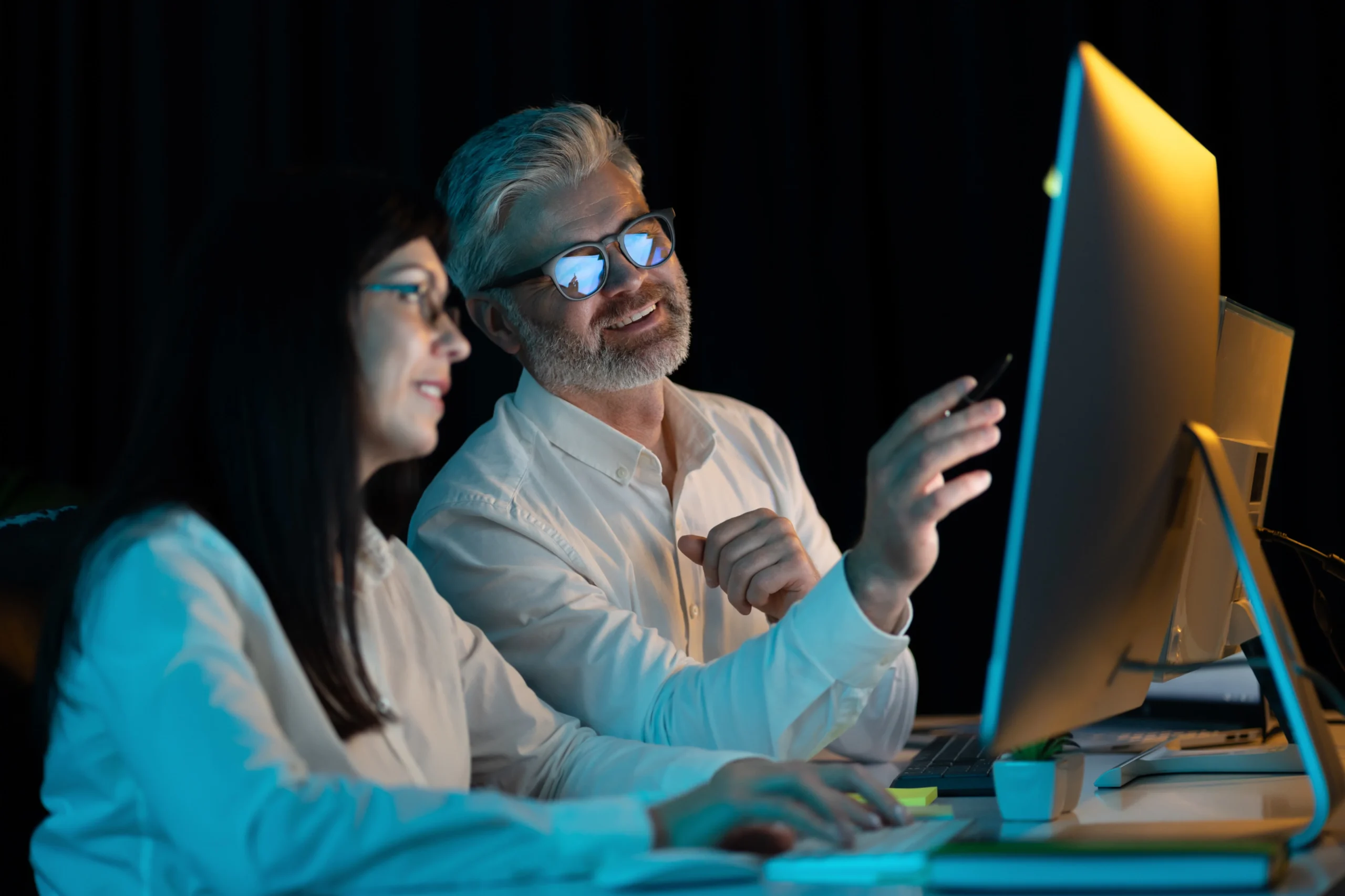 Colleagues discussing SEO and SEM strategies while analyzing data on a computer screen.