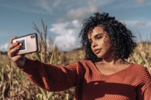 Woman taking a selfie outdoors to create user-generated content